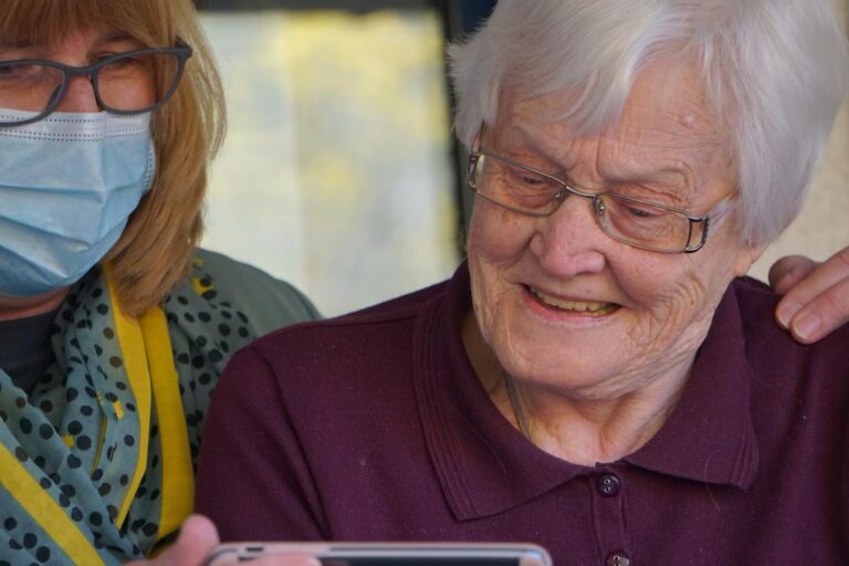 An elderly woman holding a smartphone horizontally