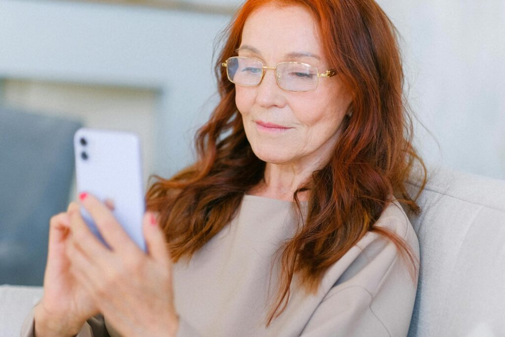 A senior woman using her smartphone, reviewing her Medicare benefits and coverage options.