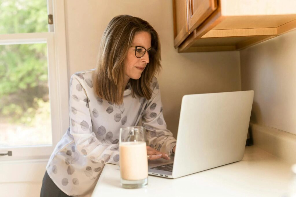 A woman thoughtfully reviewing Medicare Advantage plans on her laptop, symbolizing informed decisions for health and wellness in retirement.