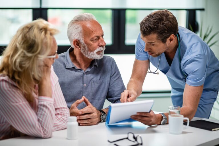 Doctor reviewing healthcare documents with a senior couple.