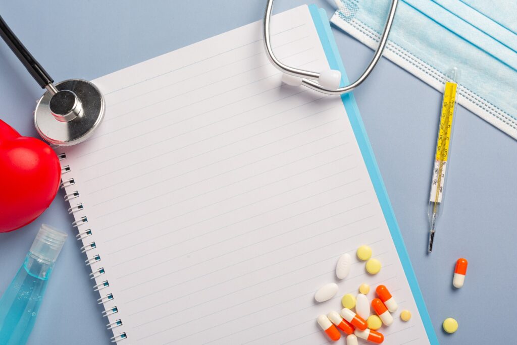 Medical notepad with pills, stethoscope, and thermometer