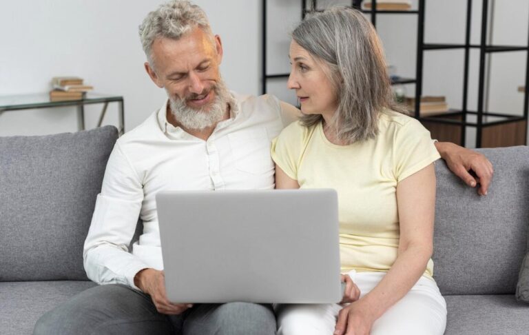 An elderly couple sitting together, thoughtfully reviewing new Medicare cuts.