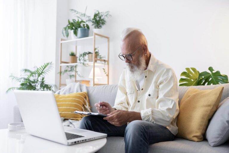 A senior citizen reviewing a Medicare plan on a laptop at home.
