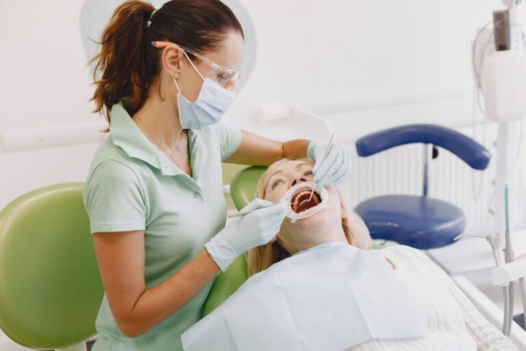 a dentist wearing a mask, treating an older woman's teeth