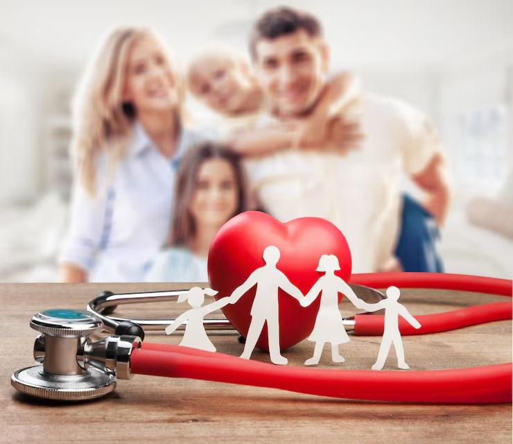 a family of four sitting behind a red stethoscope with a heart, and cut out of a family from paper
