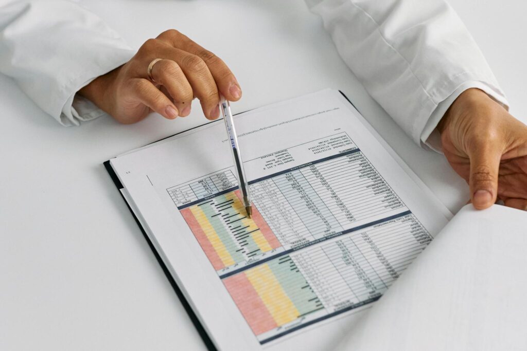 close-up of a person in a white coat going through a color-coded list