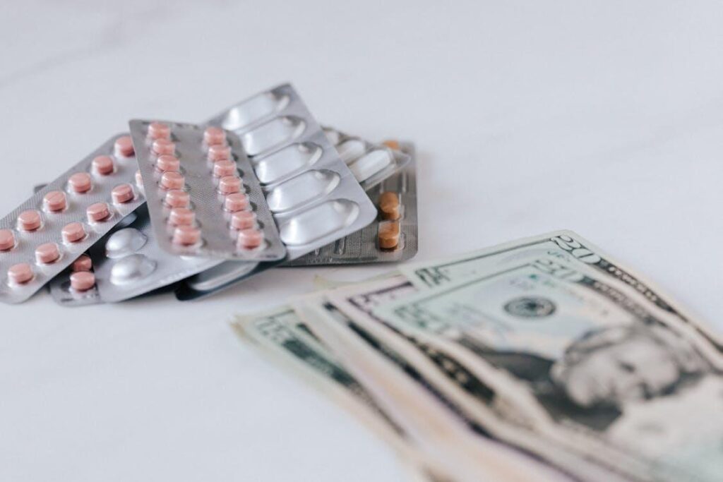 a pile of medicines placed next to a pile of cash on a table