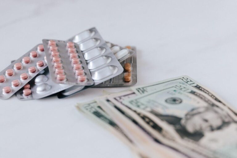 a pile of medicines placed next to a pile of cash on a table