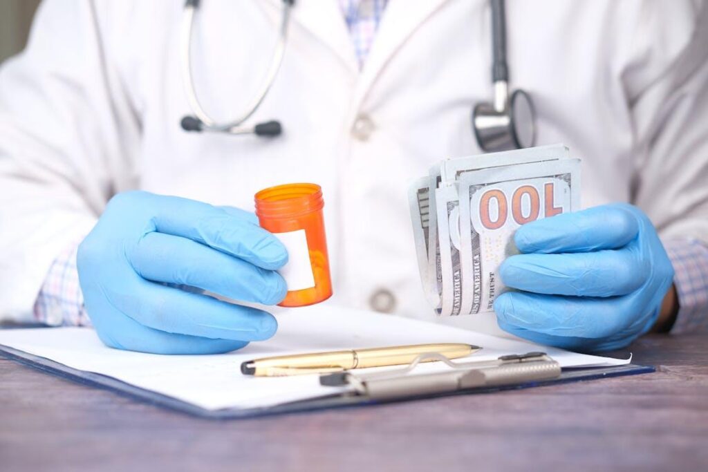 close-up of a healthcare professional holding medicine and money in their hands