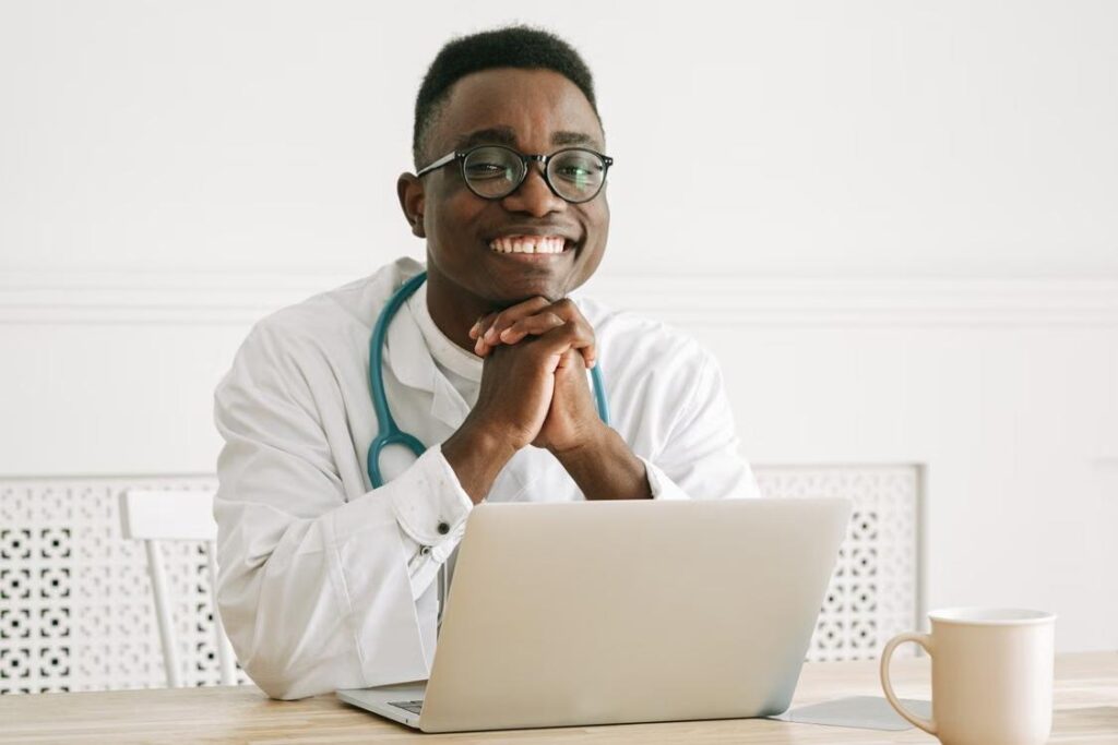 A smiling doctor wearing a stethoscope in a clinical setting.