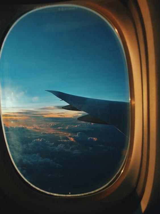A view of the sky and airplane wing from a window seat.