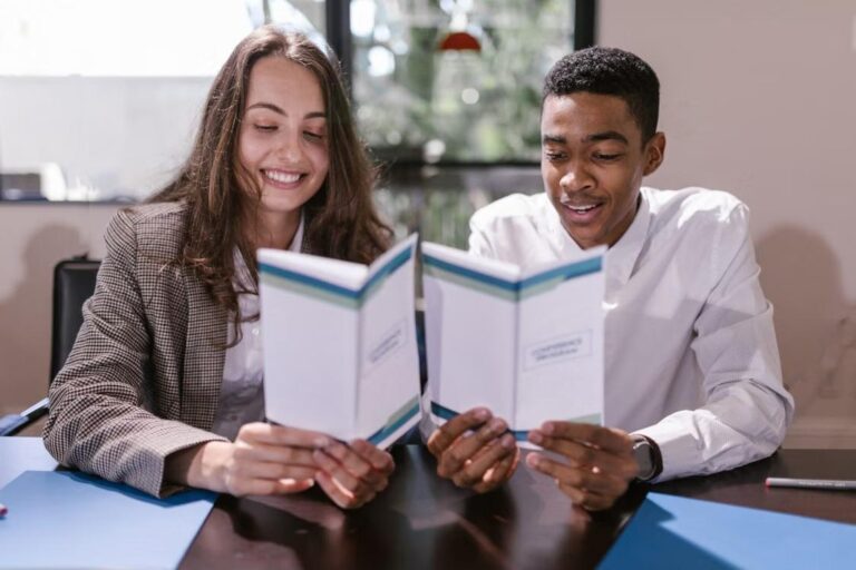Two colleagues reviewing documents together in a bright office setting.