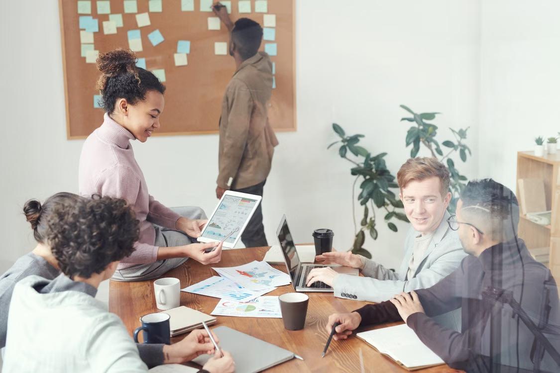 A diverse group of colleagues collaborate together in an office setting.