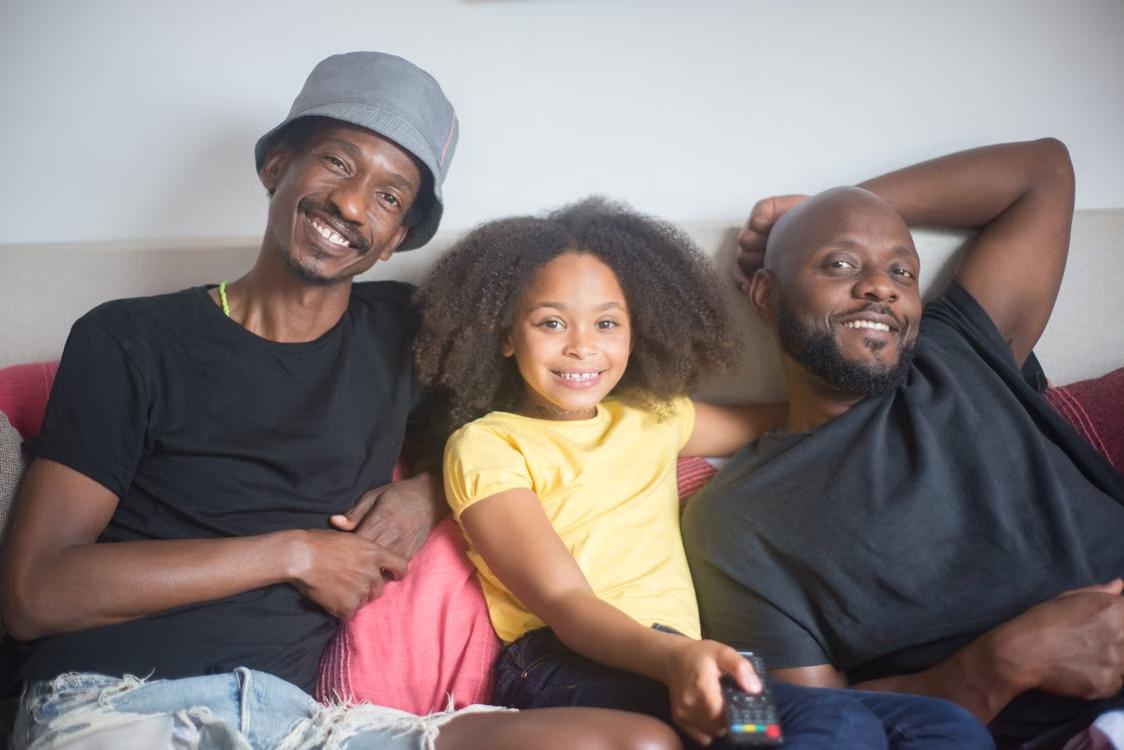 A family smiles together while relaxing at home.